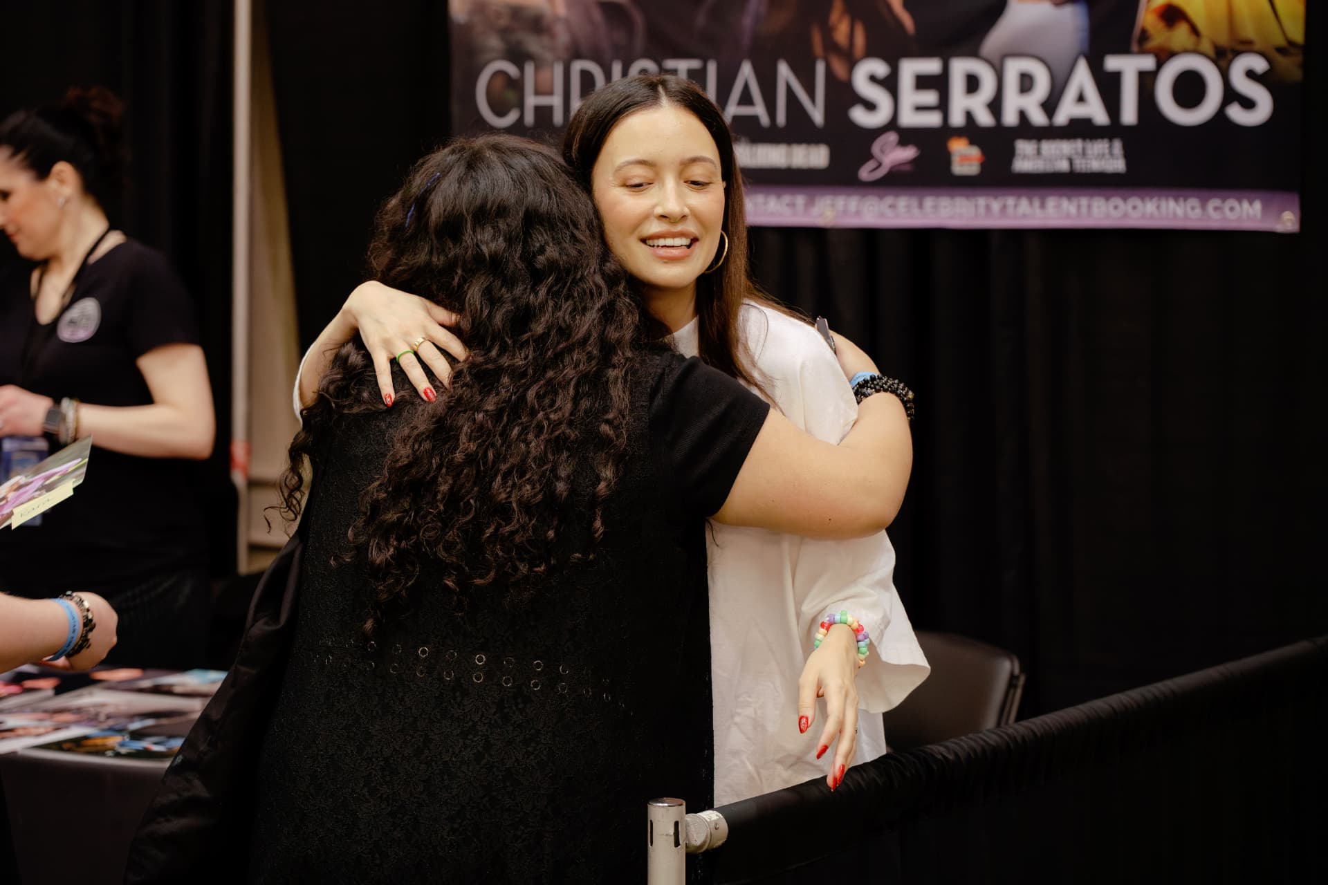Christian Serratos hugging a fan at her signing table