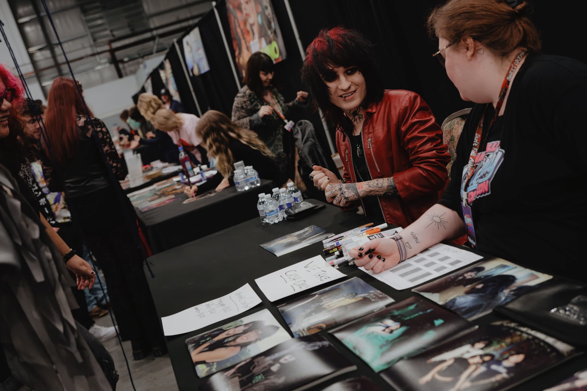 A guest chatting with a fan across a signing table