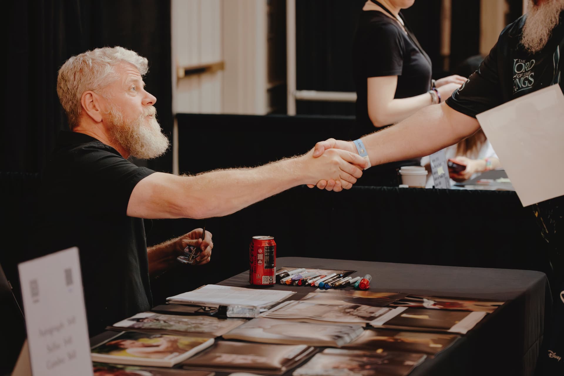 A guest greeting a fan across a signing table